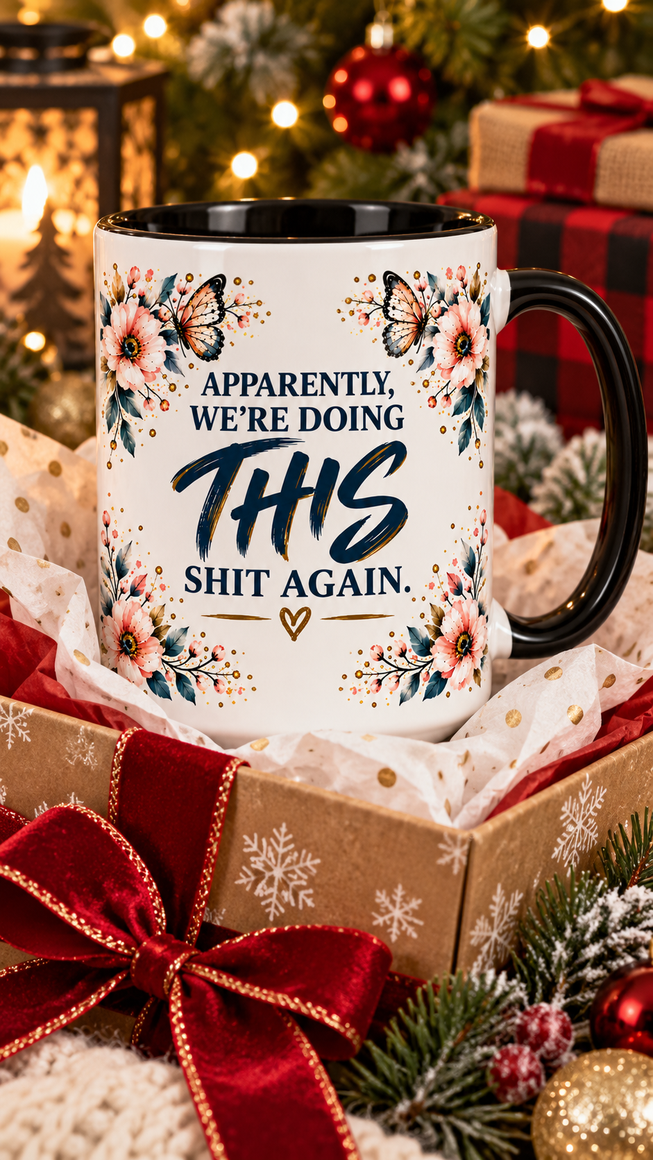 A white ceramic mug with a black handle and interior, printed with the phrase 'APPARENTLY, WE'RE DOING THIS SHIT AGAIN' in black and navy lettering, surrounded by floral and butterfly illustrations. The mug is presented in a gift box with red ribbon and tissue paper, surrounded by Christmas decorations like pine branches, ornaments, and wrapped gifts.