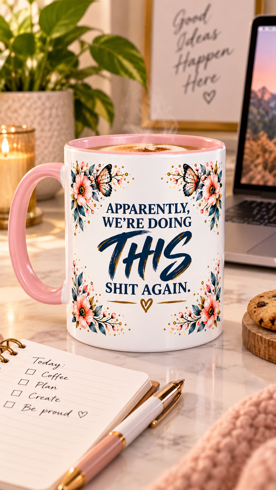 A white ceramic coffee mug with a pink handle and rim, decorated with floral illustrations and the text 'APPARENTLY, WE'RE DOING THIS SHIT AGAIN.' in blue and black lettering.
